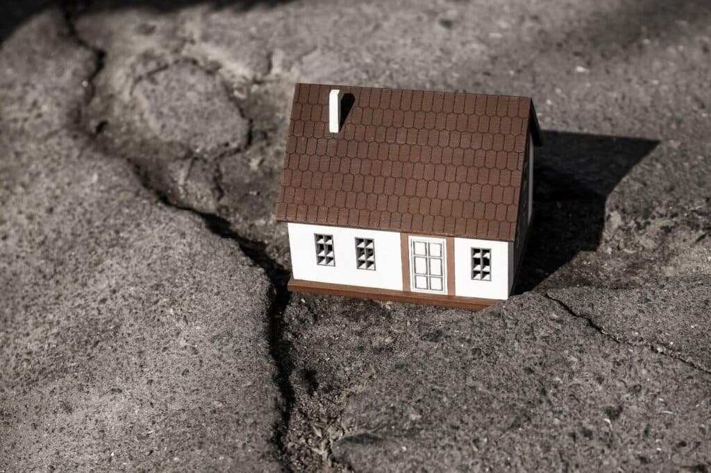 Small house perched in a crack on the ground
