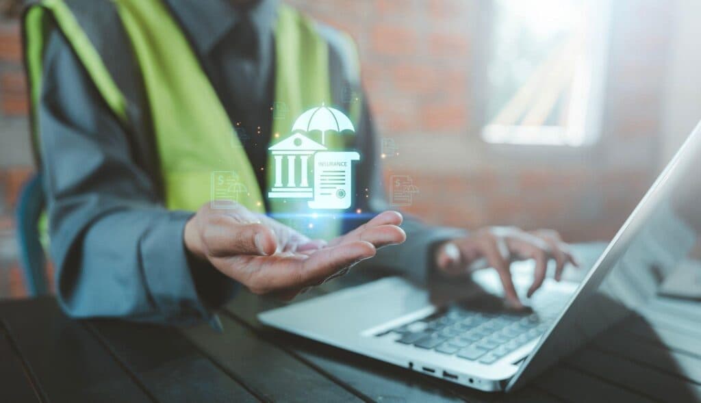 A man holds a laptop displaying a security icon symbolizing digital safety and cybersecurity awareness