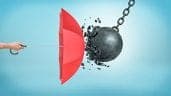 A person holding a red umbrella over a ball and chain. Image representing 'Utah Umbrella Insurance Quotes'